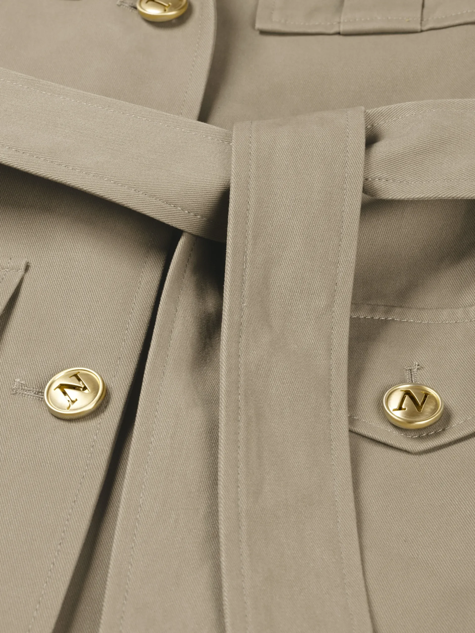 Jas met ceintuur en ketting detail