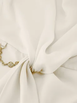 Losvallende top met gedraaid knoop detail en ketting accent